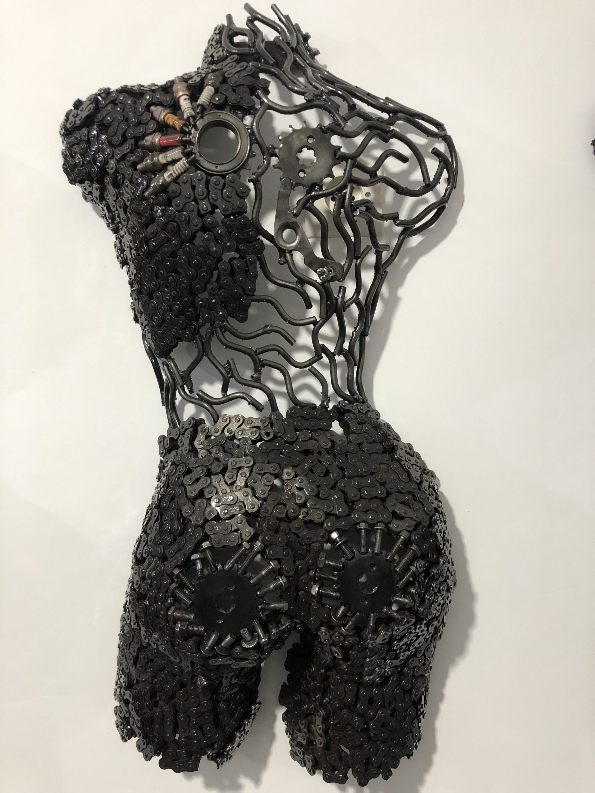 Intricate steel sculpture crafted with recycled engine parts and horseshoes